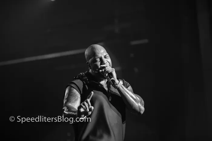 Flo Rida wagging his finger with eyes closed while rapping, black and white