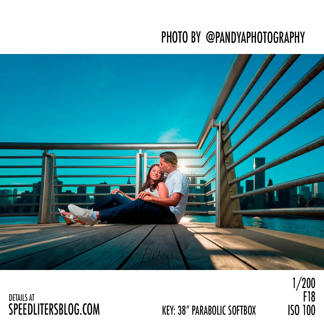 Couple sitting on a waterfront pier with the city skyline behind, photo by Pandya Photography
