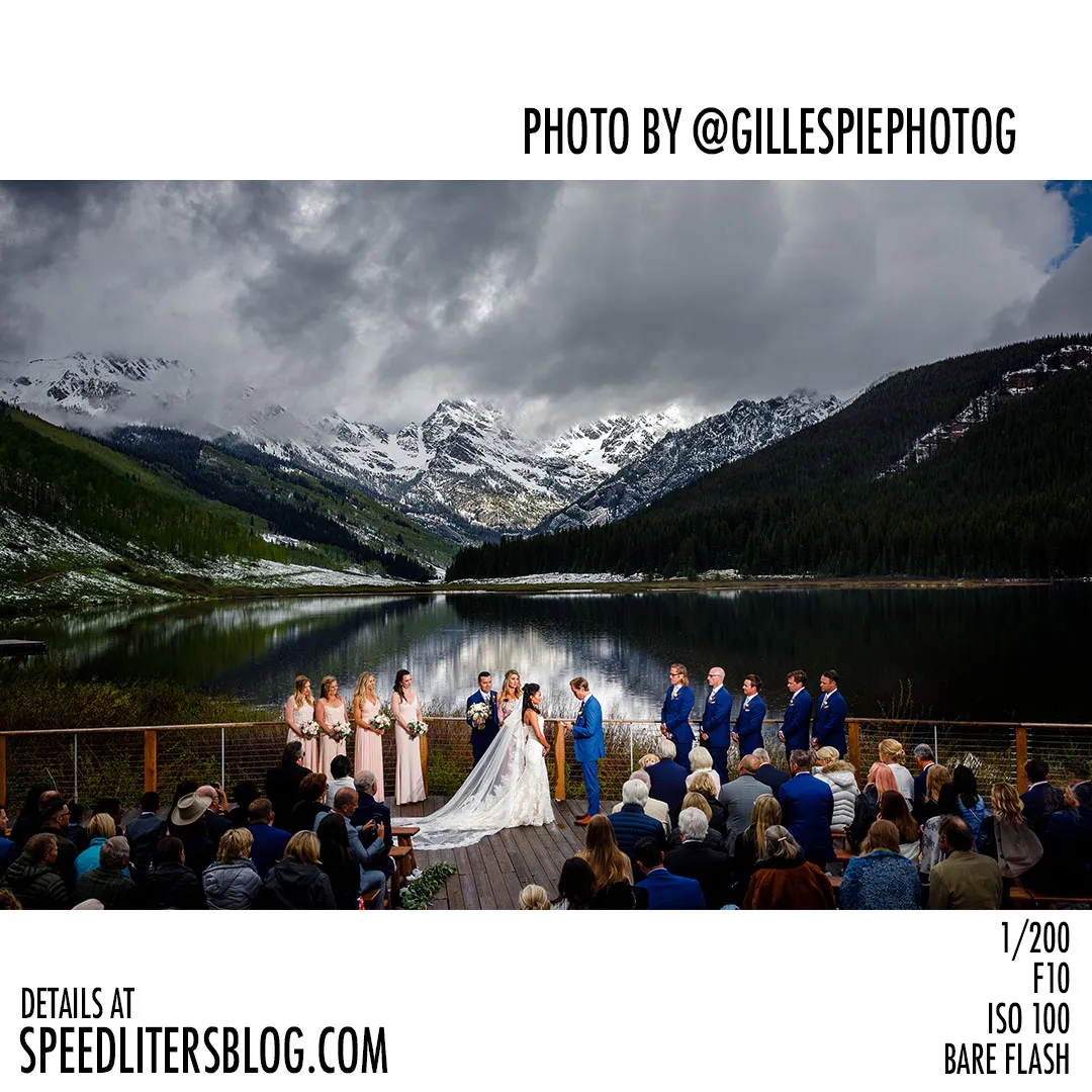 Wedding ceremony on a lakeside deck below snowy Colorado mountains, by Gillespie Photography