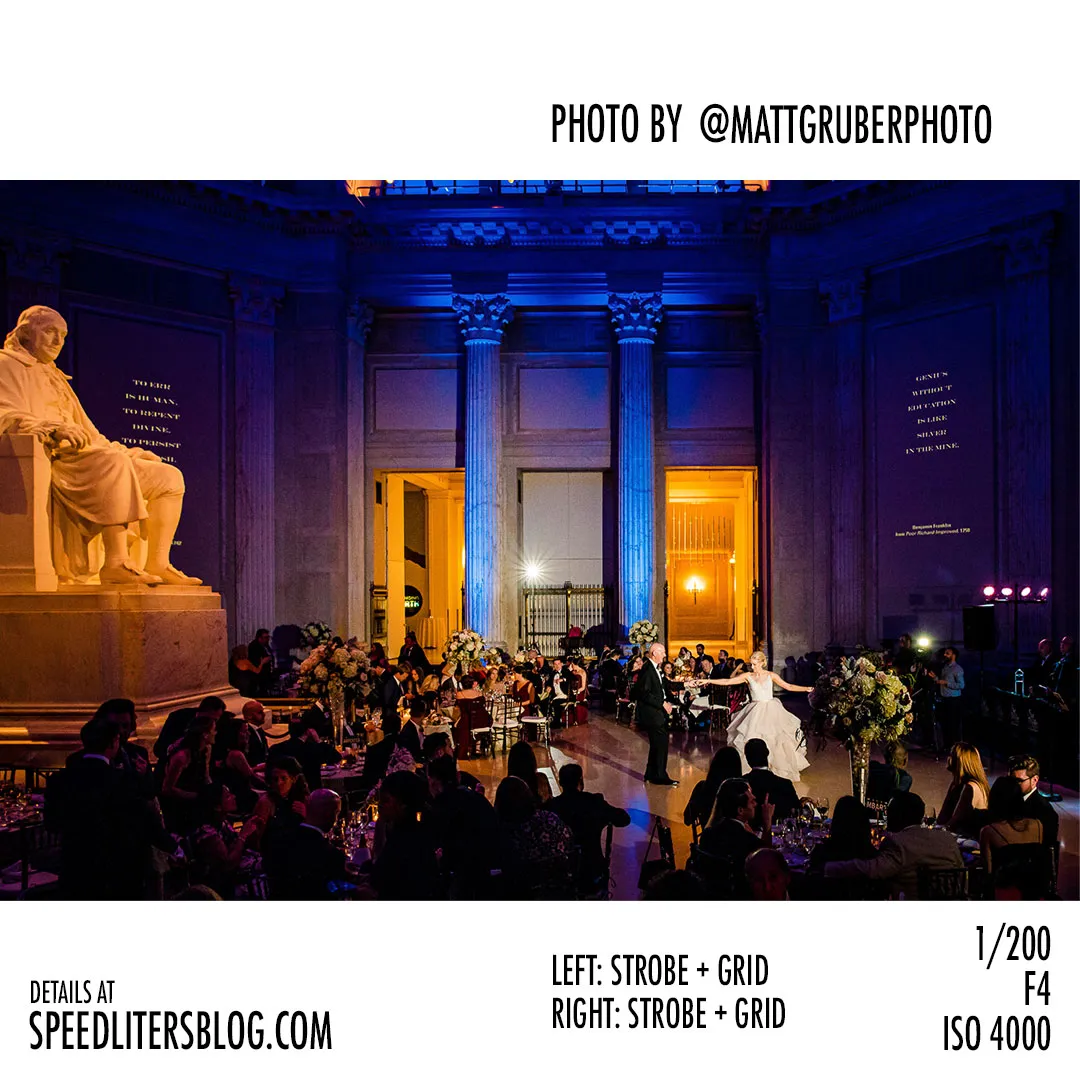 Wedding reception in a grand hall with a blue-lit statue of Benjamin Franklin, by Matt Gruber