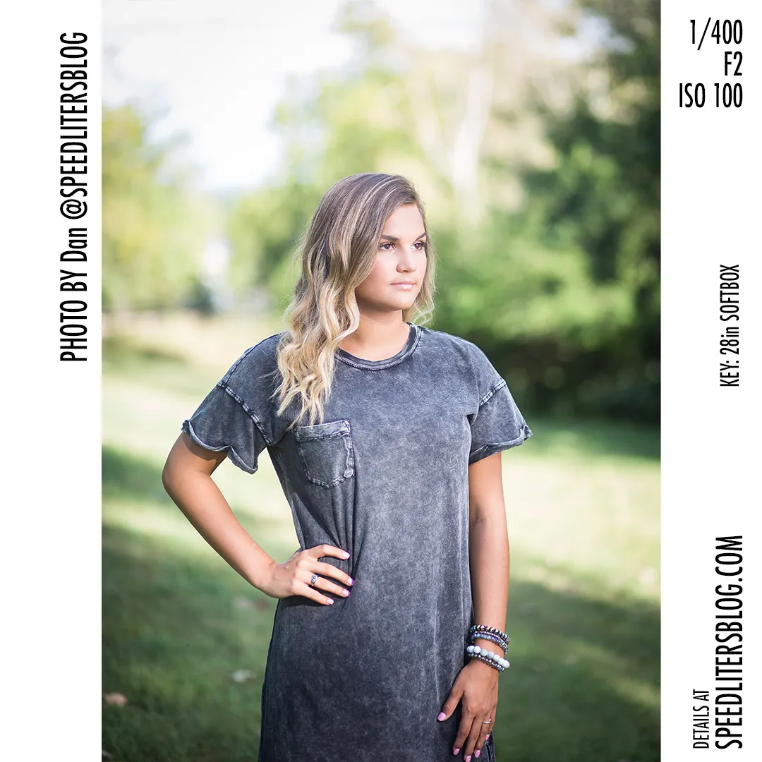 Senior girl in a gray T-shirt dress with her hand on her hip, lit by a softbox