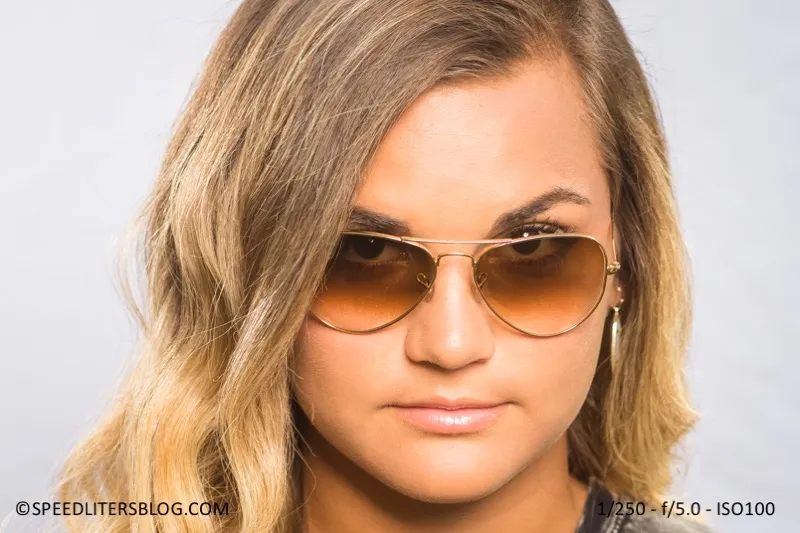 Close-up of a senior girl in aviator sunglasses against a white background