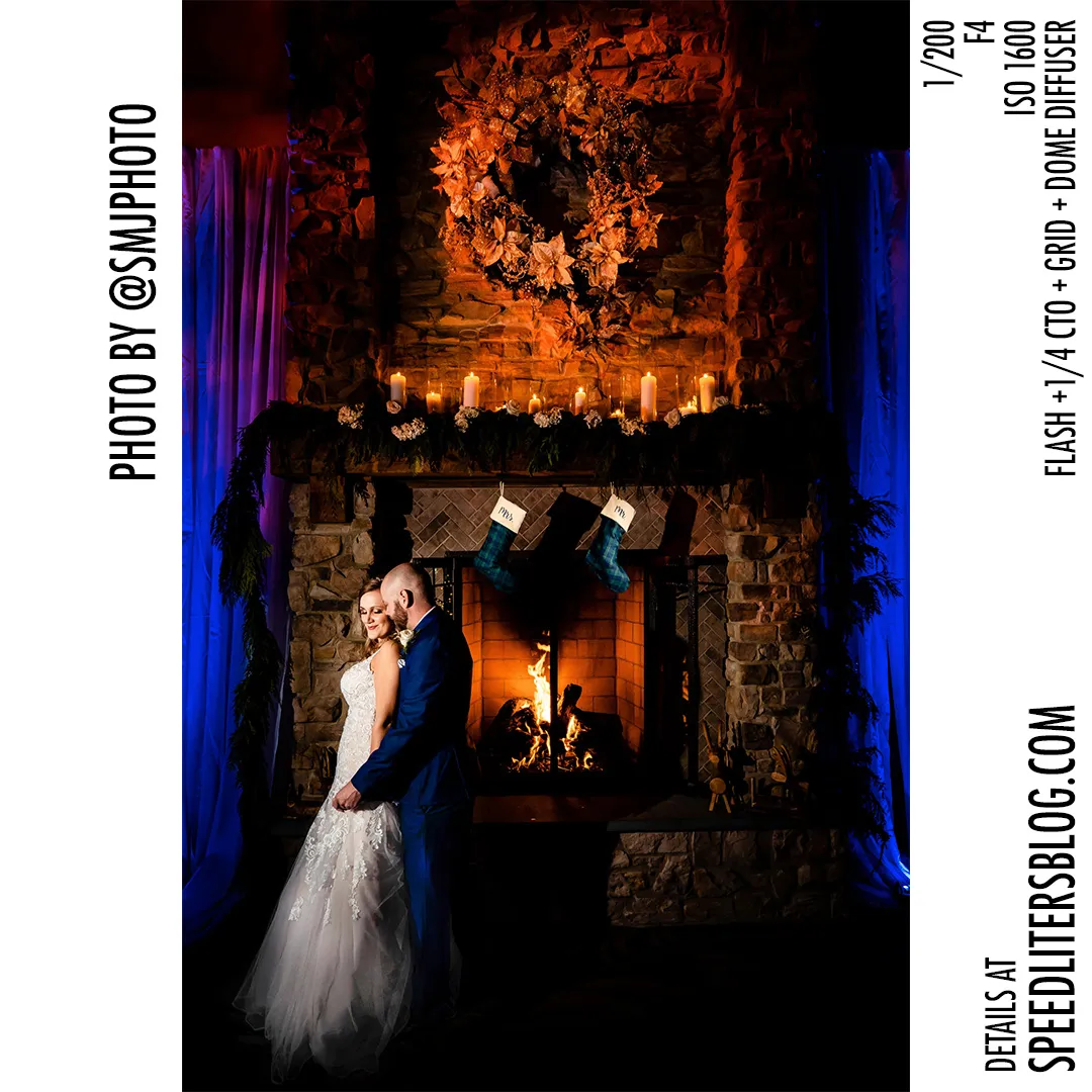 Bride and groom by a decorated stone fireplace with blue light, by SMJ Photography