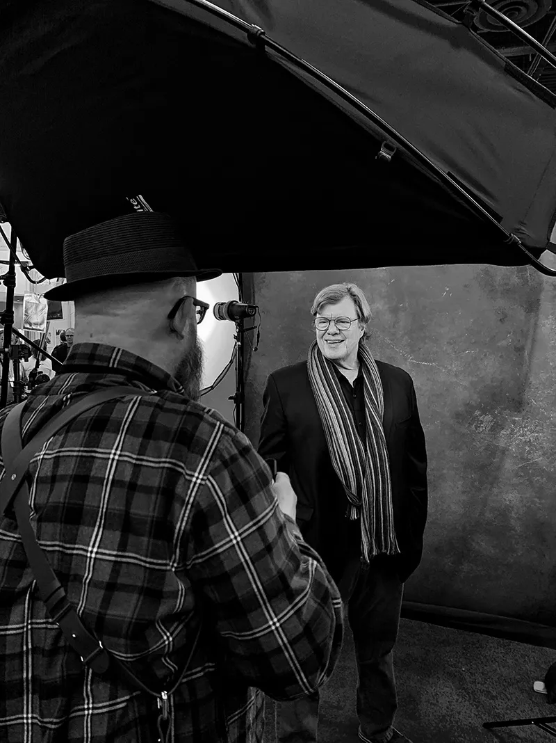 Black-and-white behind the scenes of Walter van Dusen photographing a man in a scarf