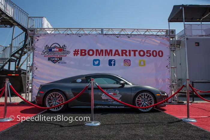 Sports car on a red carpet in front of a Bommarito 500 race banner